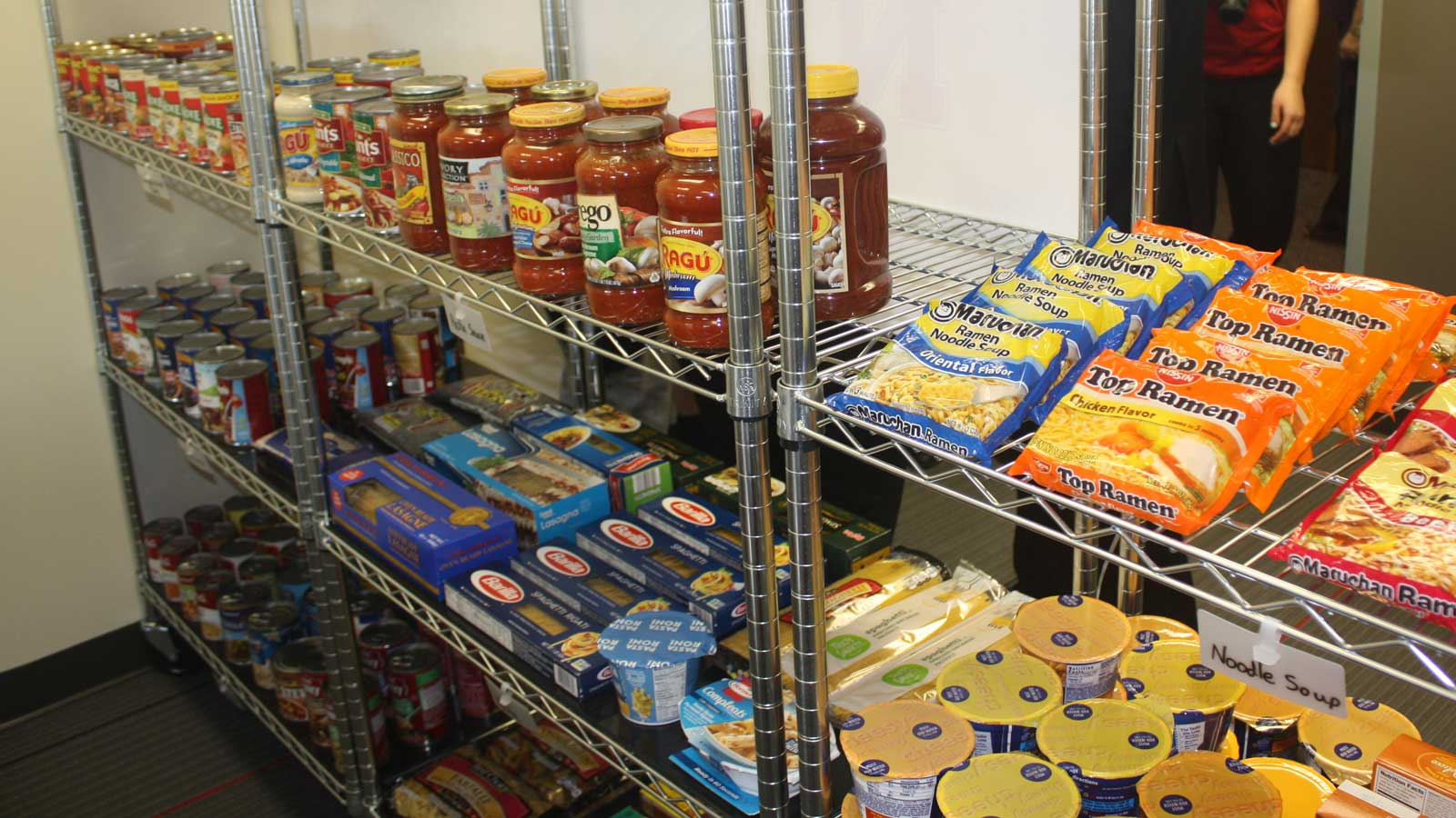 Shelf with pasta sauce, ramen noodles and other products in the on-campus pantry
