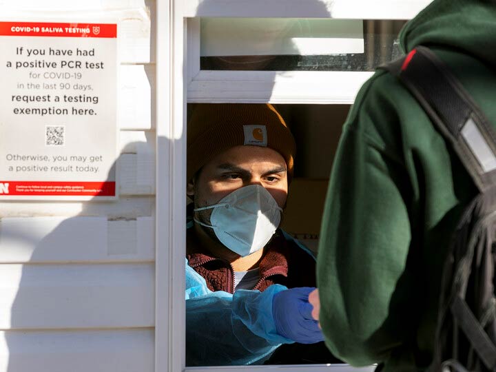 A student delivers a vial of saliva at the Nebraska Union COVID-19 test location on Jan. 18. All students, faculty and staff are going through re-entry testing at the start of the spring semester. The testing system will shift to focus on residence halls and Greek houses next week.