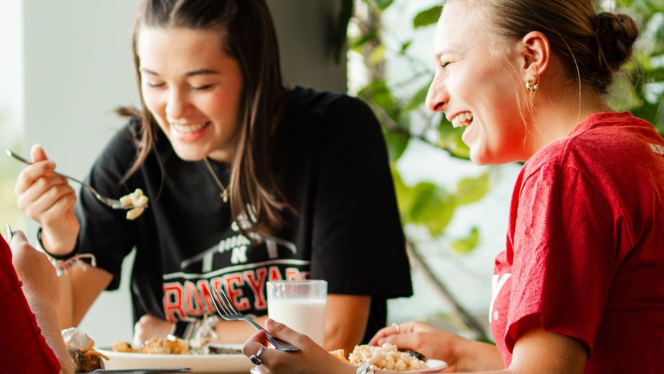Students laugh as they enjoy a meal together in the dining center.