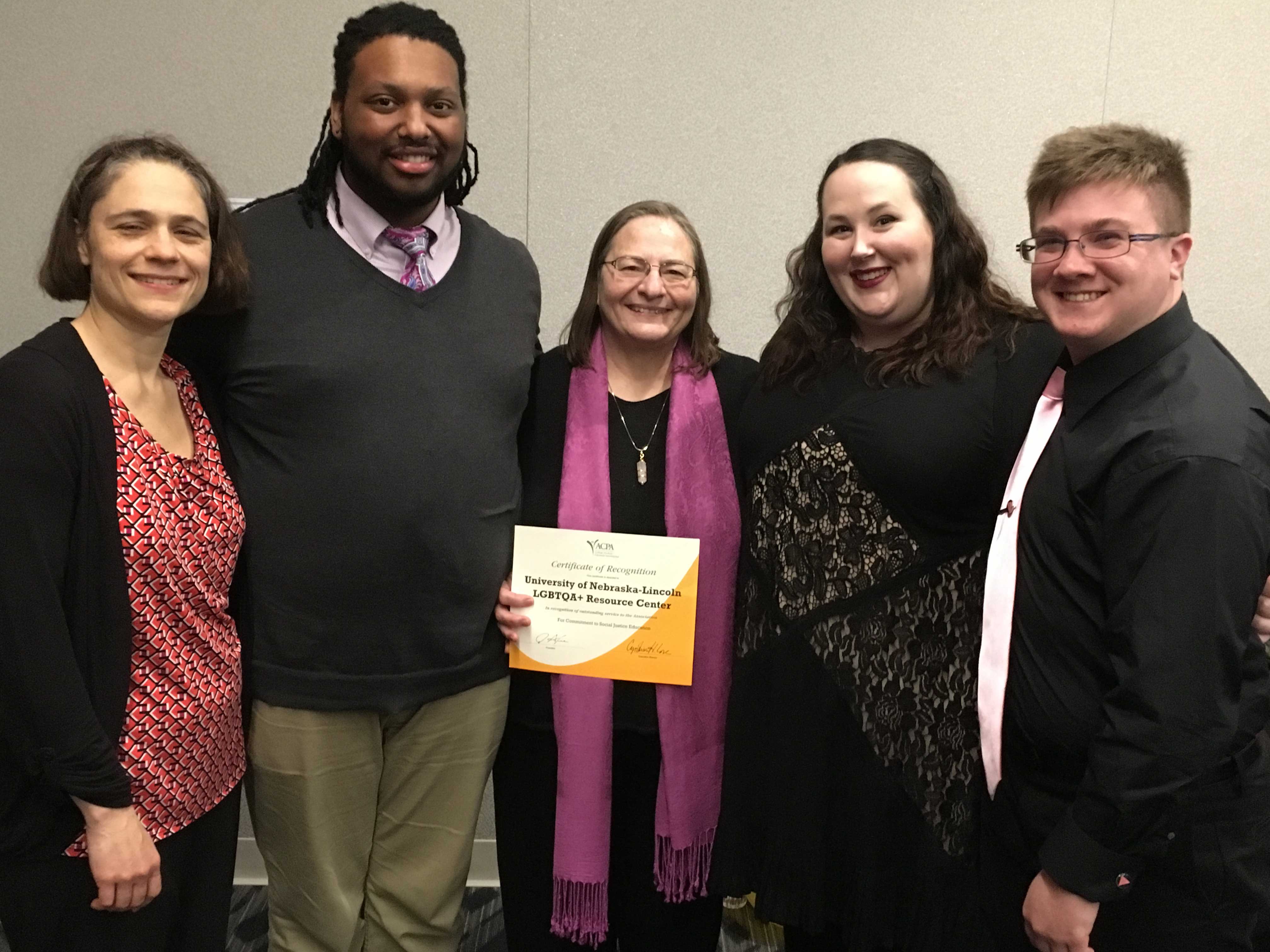 The Nebraska LGBTQA Resource Center accepts an ACPA award for Commitment to Social Justice Education.