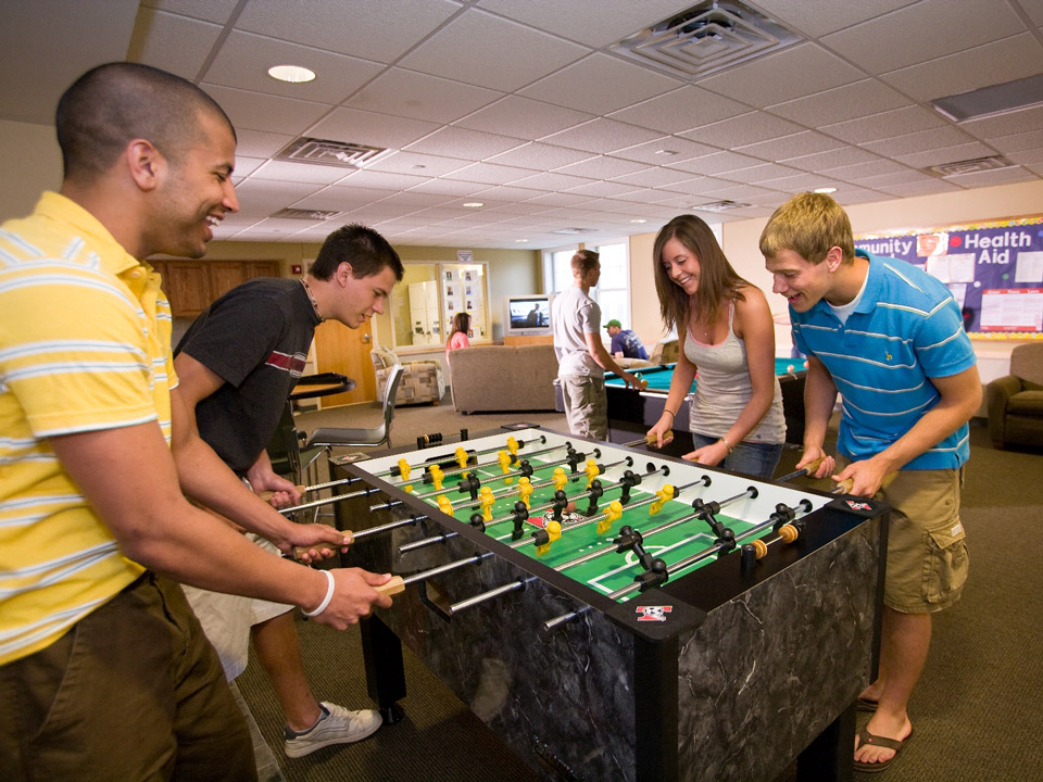 Students play foosball in a residence hall game room