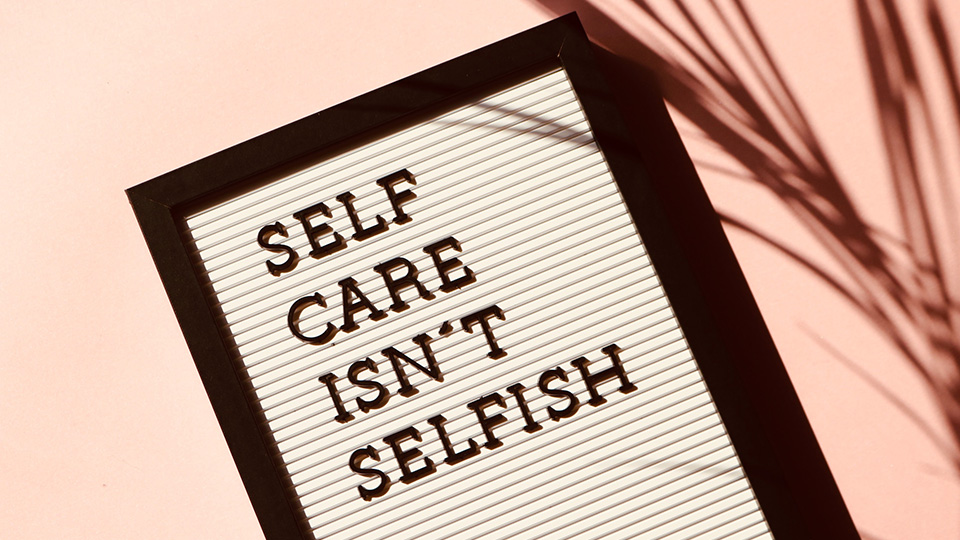 A letter board with the phrase "self care isn't selfish"