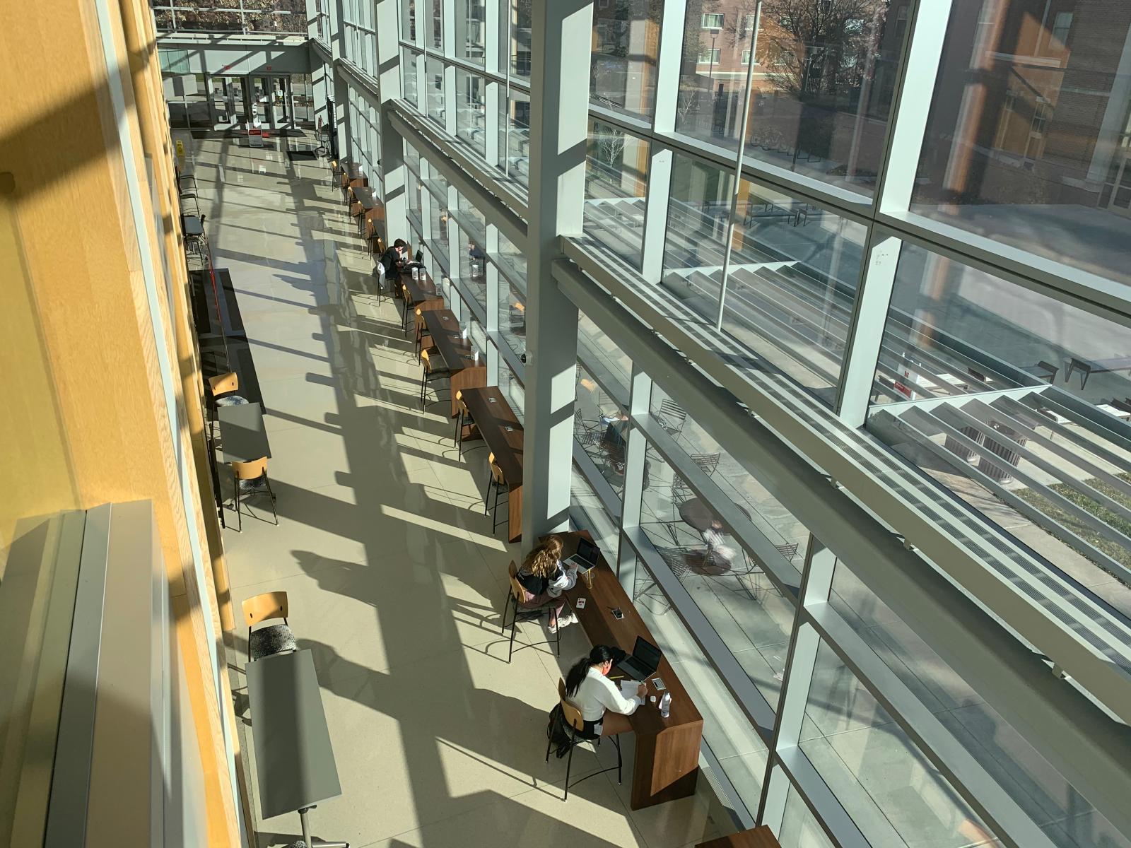 students studying next to the windows in the College of Business.