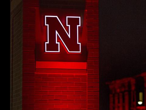 Glowing Nebraska N on brick pillar
