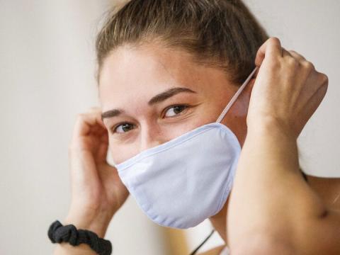 Olivia Boldt, senior from Madison, South Dakota, puts on her mask before going to work out in the Campus Recreation Center during 2020 summer sessions.