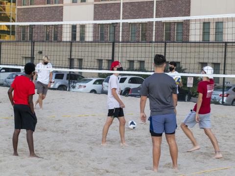 Students playing sand volleyball at the 18th & S Rec Area located north of Eastside Suites.