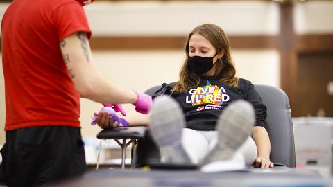 Kacey Heidbrink watches as Brandon Thelen preps her arm to donate. Students donate in the Homecoming Blood Drive in the Nebraska Union ballroom on city campus. October 27, 2020. [Photo by Craig Chandler / University Communication].