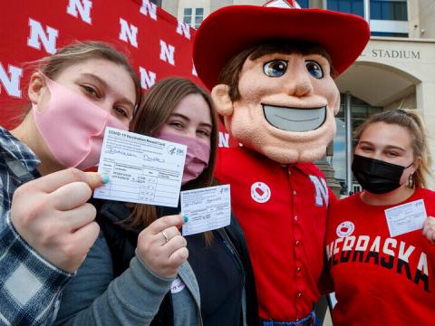 Husker students show their COVID-19 vaccination cards