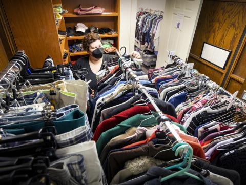 JD McCown, assistant director of the LGBTQA+ Center, arranges donated clothing in the Lavender Closet June 6. [Craig Chandler | University Communication and Marketing]