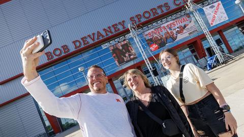 Marissa Brewer of Omaha (right) poses for a selfie with her mom and dad, John and Michelle, as they enter Devaney Sports Center to start the move in process. [Craig Chandler | University Communication and Marketing]