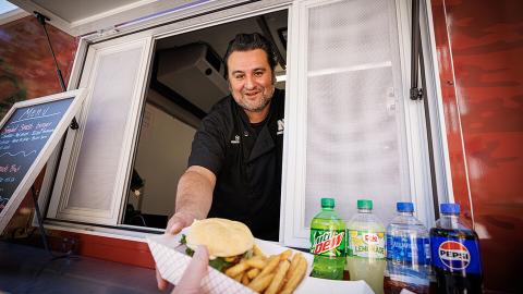 Otto Meza serves food from the Harper Smokehouse Food Truck