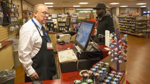 Ian McLean (left) talks with then-student Hakim Abdilahi at the University Bookstore's NU Market in this file photo from Oct. 30, 2015. McLean is retiring after 16 years of service at the bookstore. A retirement reception is 11 a.m. to 1 p.m. May 24.
