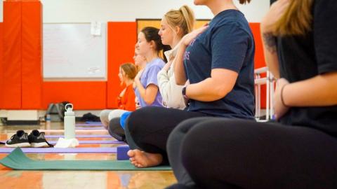Students participate in a Basics Meditation group fitness class at Campus Recreation Center.