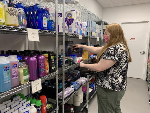 Graduate assistant Katie Peterson restocks the product shelves on the first day that in-person visits resumed at Husker Pantry. May 12, 2021. [Christopher Dulak | Student Affairs]