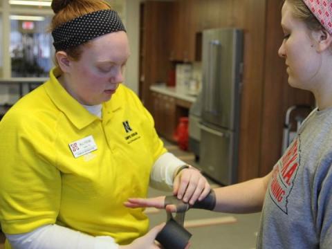 Athletic training student wraps the wrist of another student.