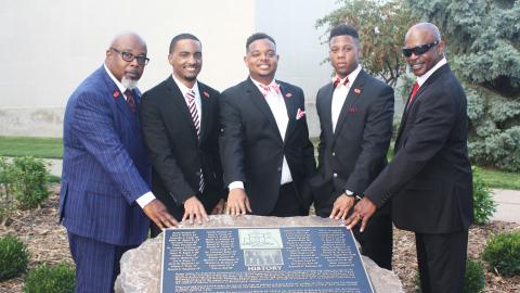 Members of Kappa Alpha Psi fraternity with new rock located south of the Nebraska Union