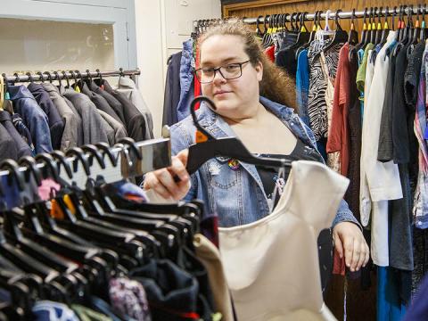 Alyssa Mettler, graduate assistant in the LGBTQA+ Resource Center, organizes clothes in the newly opened Lavender Closet.