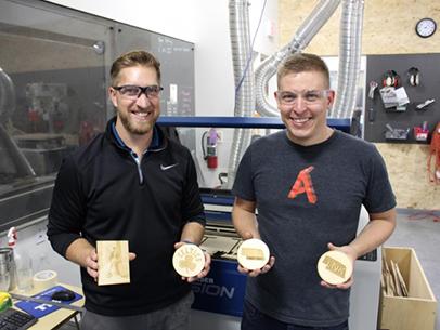 Makers hold up their creations at Nebraska Innovation Studio. [Photo from NIS website]