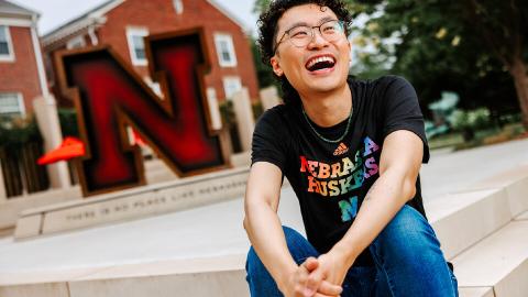 Nathan Hé laughs for a photo on the stairs of the Wick Alumni Center