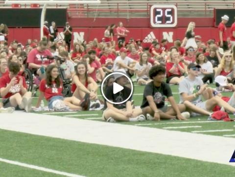 While sitting on the turf field inside Memorial Stadium, UNL students watch the Huskers football game in Ireland on the large digital screen. August 27, 2022. [KLKN]
