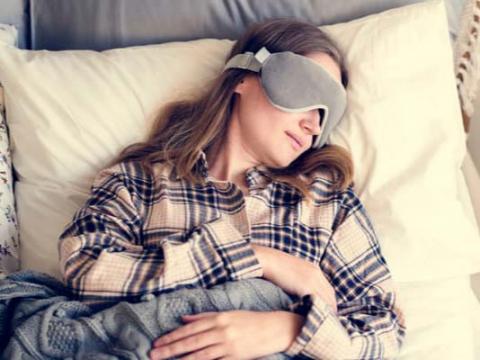 Woman sleeping in bed with mask
