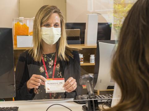 A pharmacist speaks with a UNL student about a medication at the University Health Center.