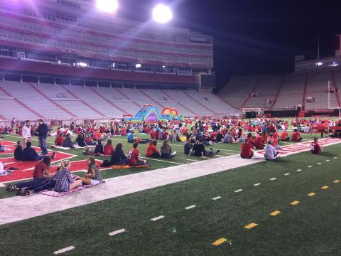 Students and UNL Family Weekend attendees on the field at the Husker Watch Party inside Memorial Stadium.