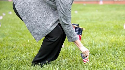 Vice chancellor for student affairs Dee Dee Anderson places a United States flag into the ground at the green space between Nebraska Union Memorial Plaza and the Kauffman Center at City Campus on Sept. 11, 2023, in Lincoln, Nebraska.  [photo by Meredith Gamet | Daily Nebraskan]