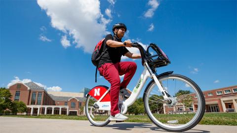 A student rides a BikeLNK bicycle on city campus.