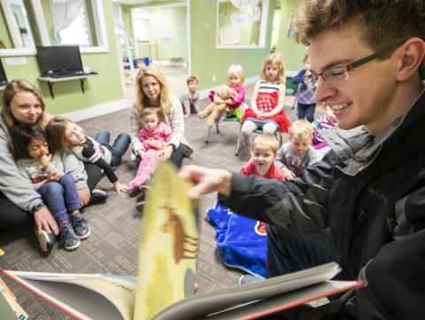 Thomas Kerr, a senior accounting major from Hastings, reads to children at the Foundations Progressive Learning Center during the Husker Reading Challenge. [Student Leadership, Involvement, & Community Engagement]