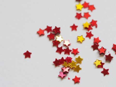 Red and gold star decorations lay on a white background.