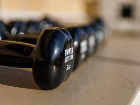 Dumbbells sit along a wall during a fitness class